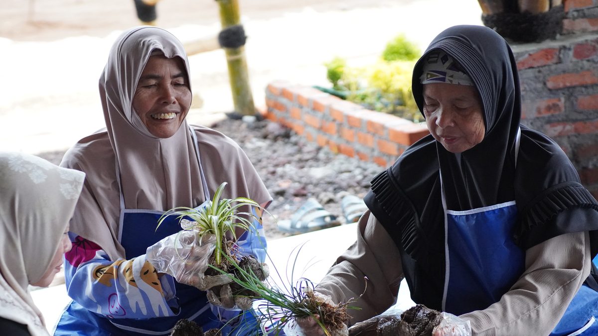Ibu-ibu warga desa mengikuti pelatihan menanam di halaman rumah